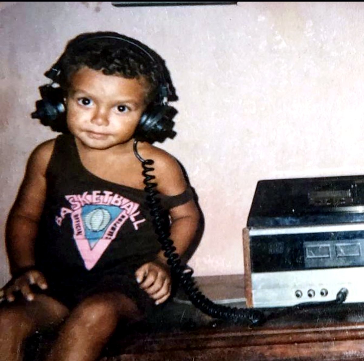 Rafael Santos criança, de fones, ao lado de um toca-fitas
